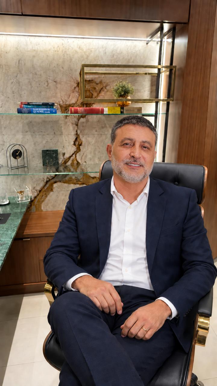 Dr. Dennison Moreira sentado no consultório